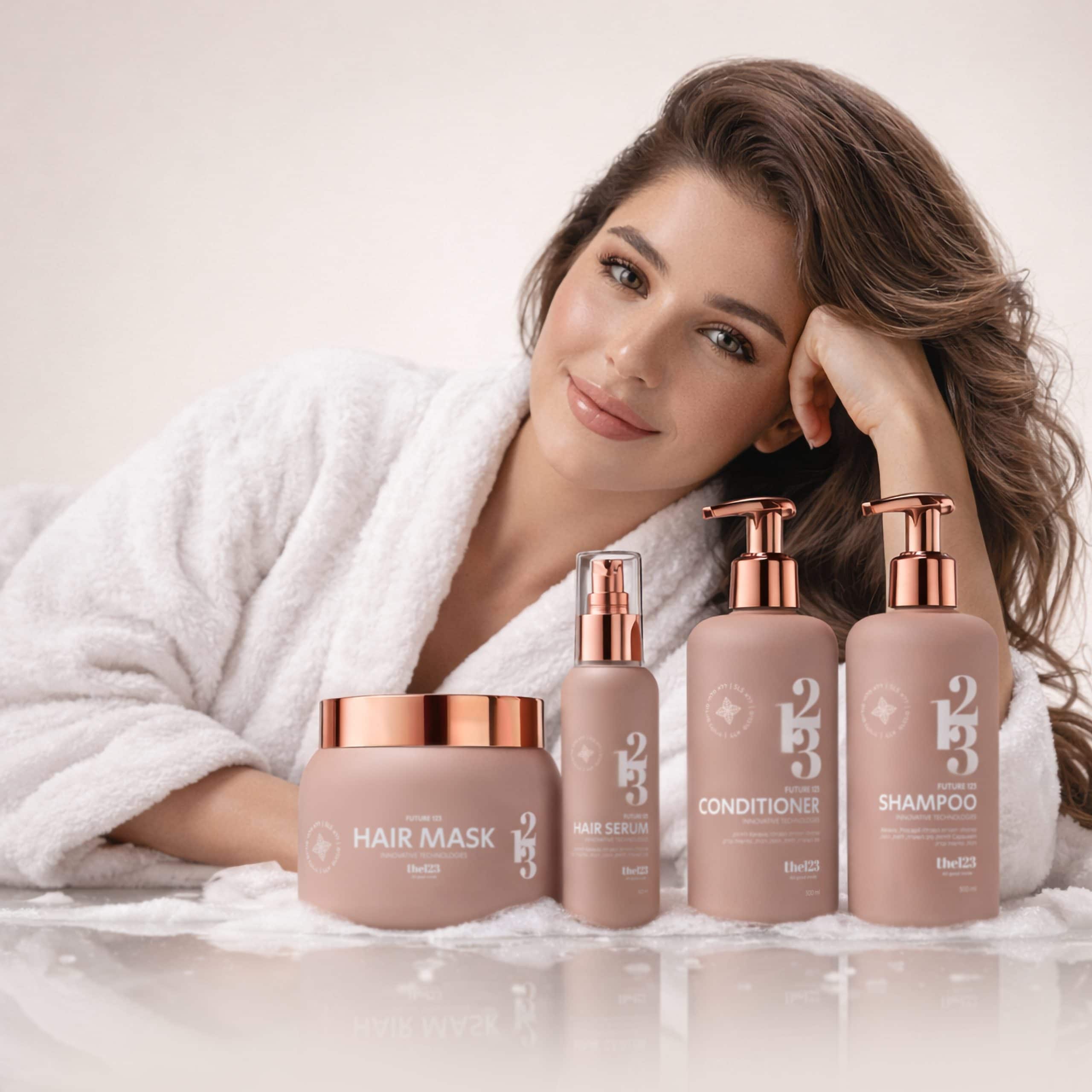 אישה נאה בחלוק אמבטיה לבן לצד ערכת פיוטשר 123 לחיזוק סיב השערה